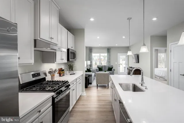 a kitchen with stainless steel appliances a sink a stove top oven a counter space and cabinets