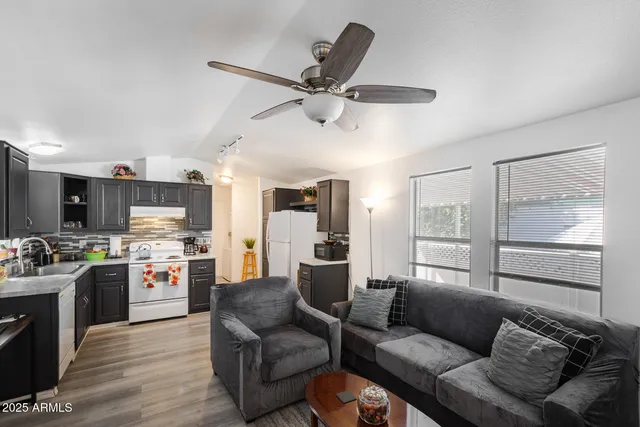 a living room with stainless steel appliances kitchen island furniture and a view of kitchen