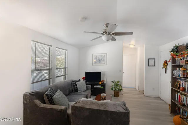 a living room with furniture a flat screen tv and a book shelf