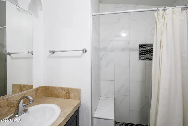 a bathroom with a granite countertop shower and a sink