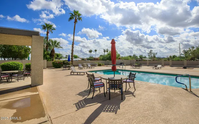 a swimming pool with outdoor seating and city view