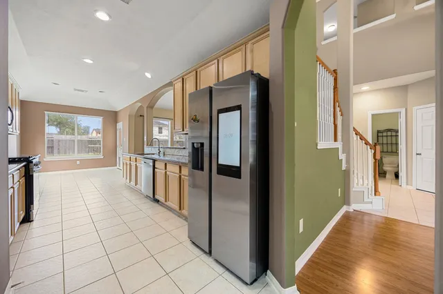 an empty room with windows and chandelier fan