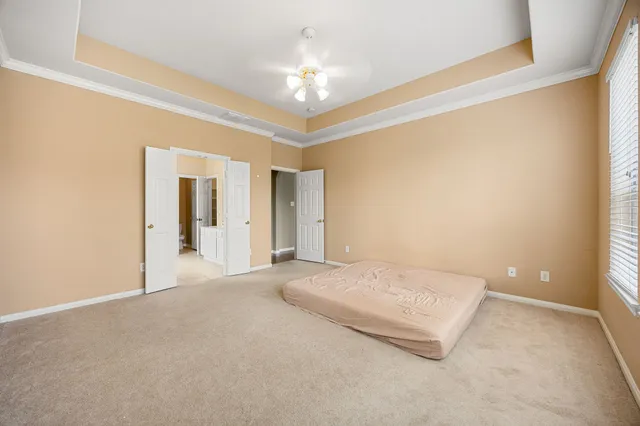 a view of an empty room with a chandelier fan