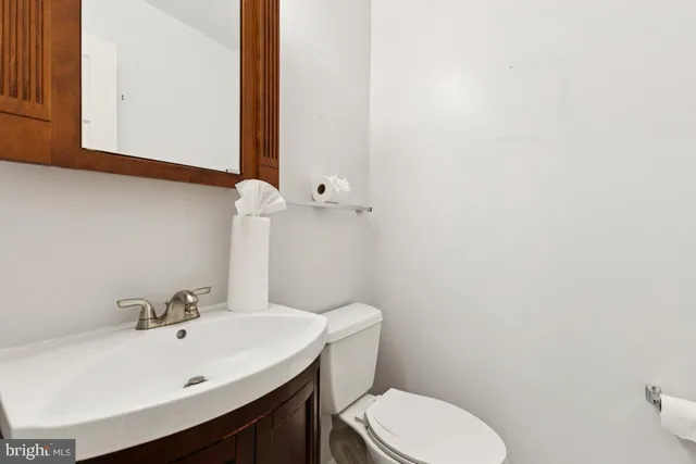 a bathroom with a sink a toilet and mirror