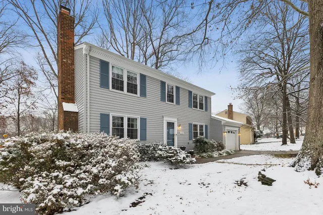 a front view of a house with a yard covered in snow