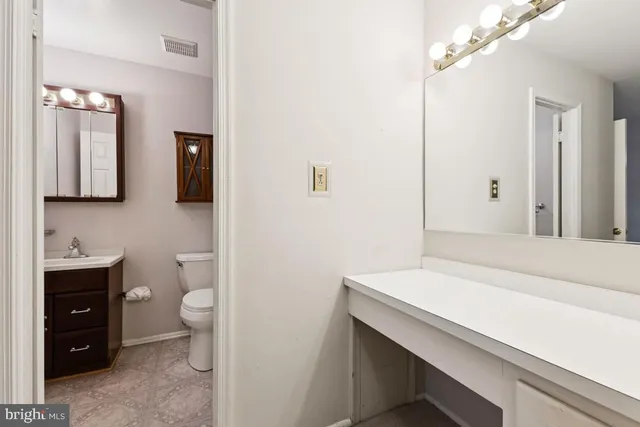 a bathroom with a sink a toilet and mirror
