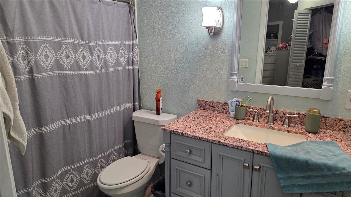 655 Chesser Avenue Sebastian, FL 32958 - Photo 8 of 17 a bathroom with a granite countertop sink vanity mirror and toilet