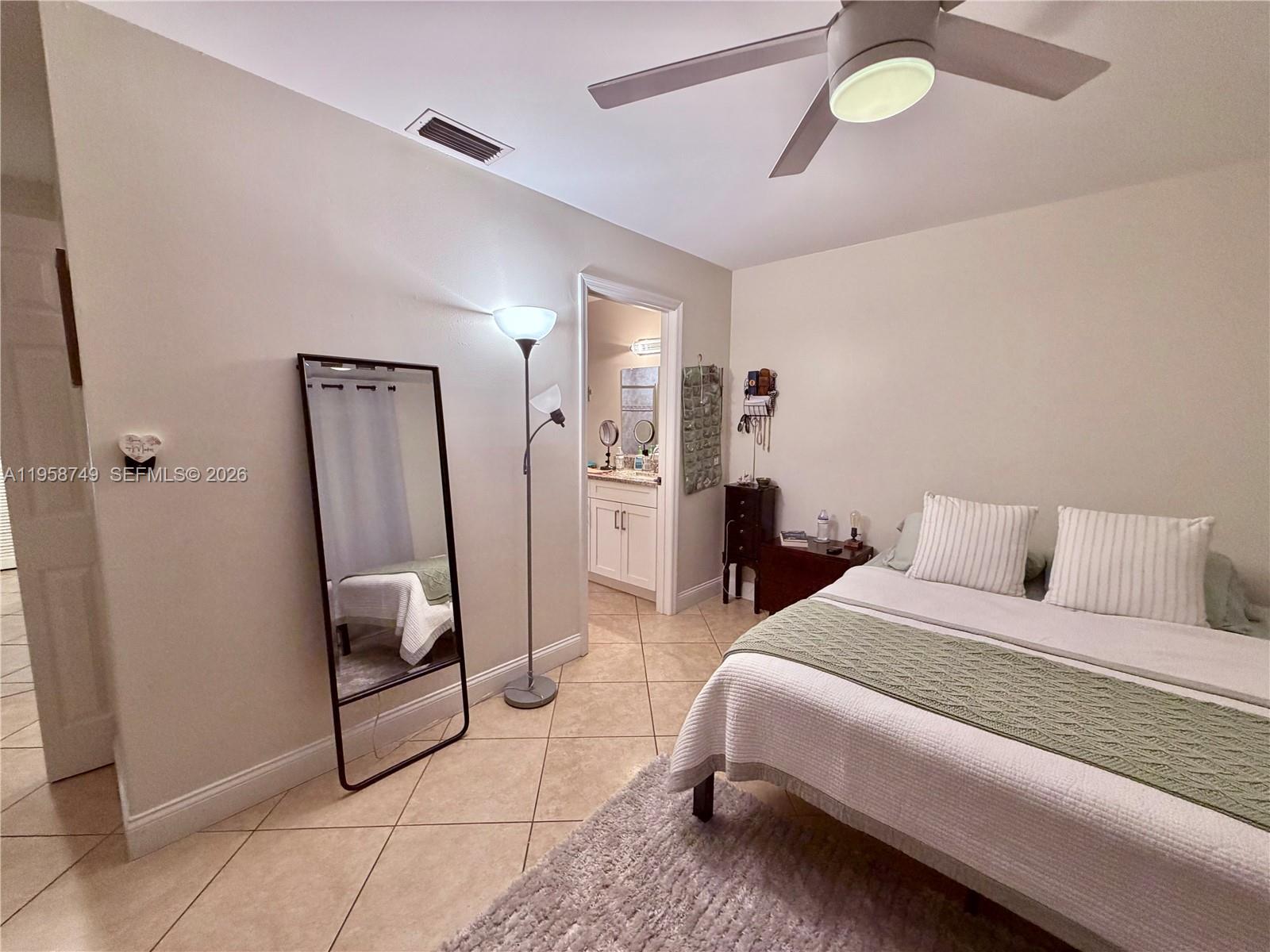 3370 Beau Rivage Drive, Unit 4Q Pompano Beach, FL 33064 - Photo 15 of 31 a bedroom with bed and a chandelier