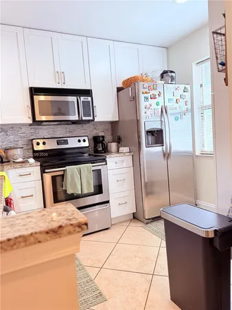 a kitchen with stainless steel appliances granite countertop a refrigerator and a stove