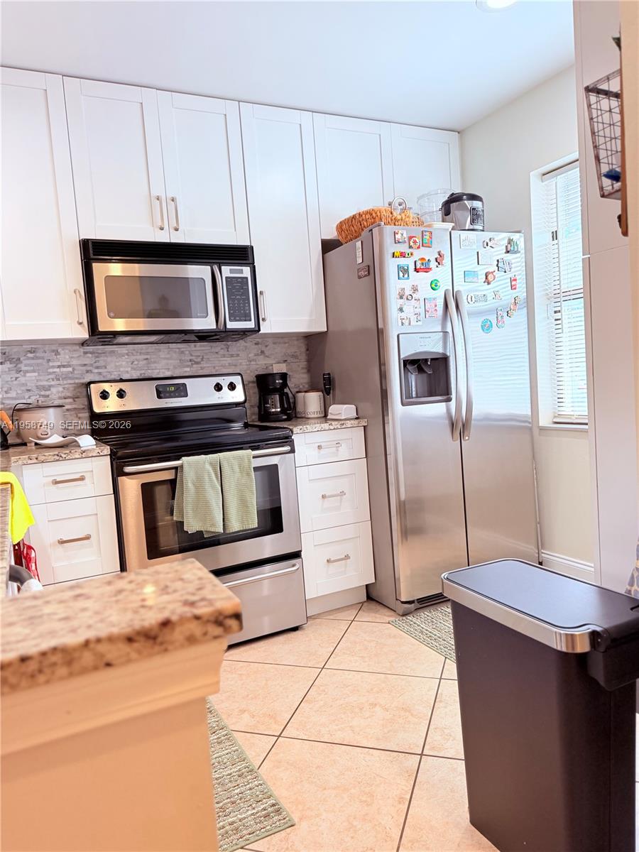 3370 Beau Rivage Drive, Unit 4Q Pompano Beach, FL 33064 - Photo 17 of 31 a kitchen with stainless steel appliances granite countertop a refrigerator and a stove