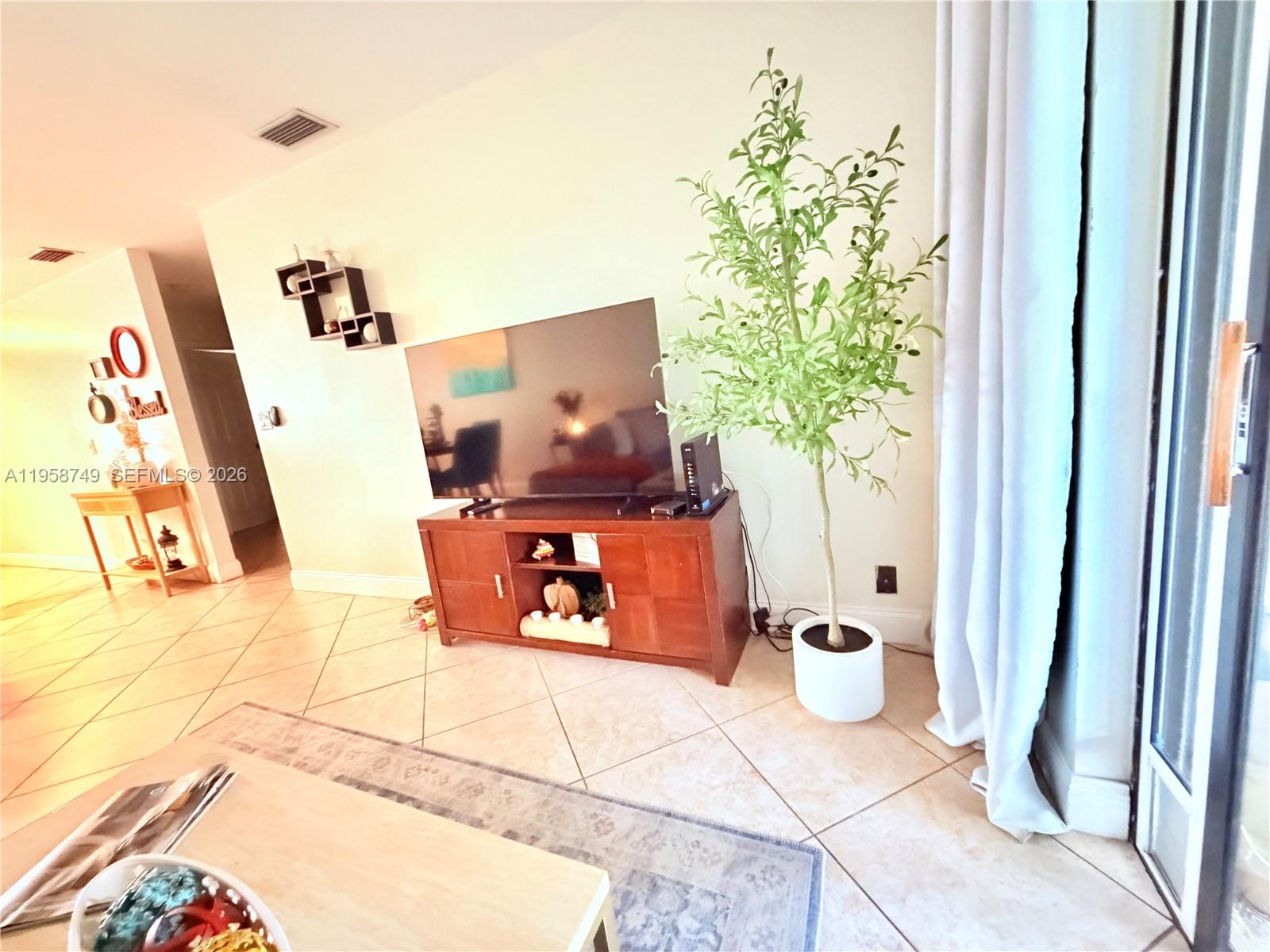 3370 Beau Rivage Drive, Unit 4Q Pompano Beach, FL 33064 - Photo 29 of 31 a room with a table and a potted plant