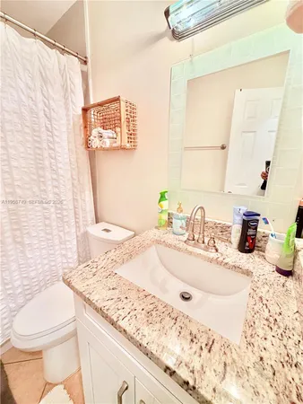 a bathroom with a granite countertop sink toilet and shower