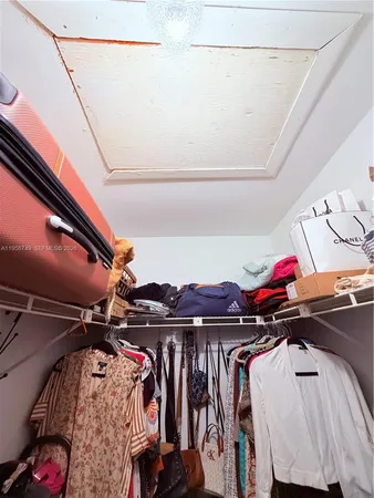 a view of walk in closet with clothes