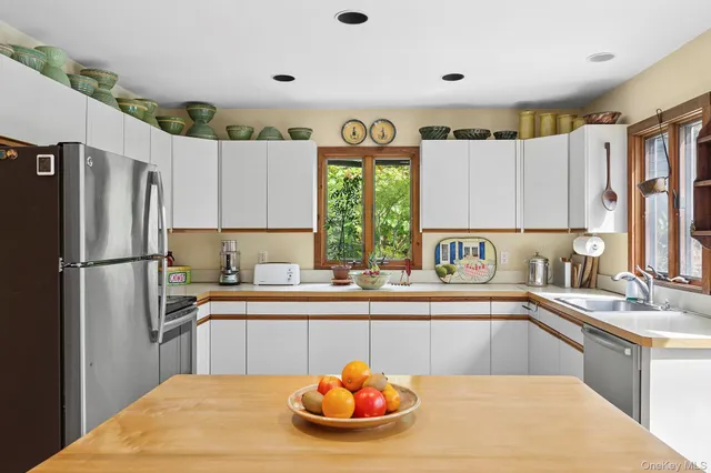 a kitchen with stainless steel appliances granite countertop a sink dishwasher a refrigerator and a stove