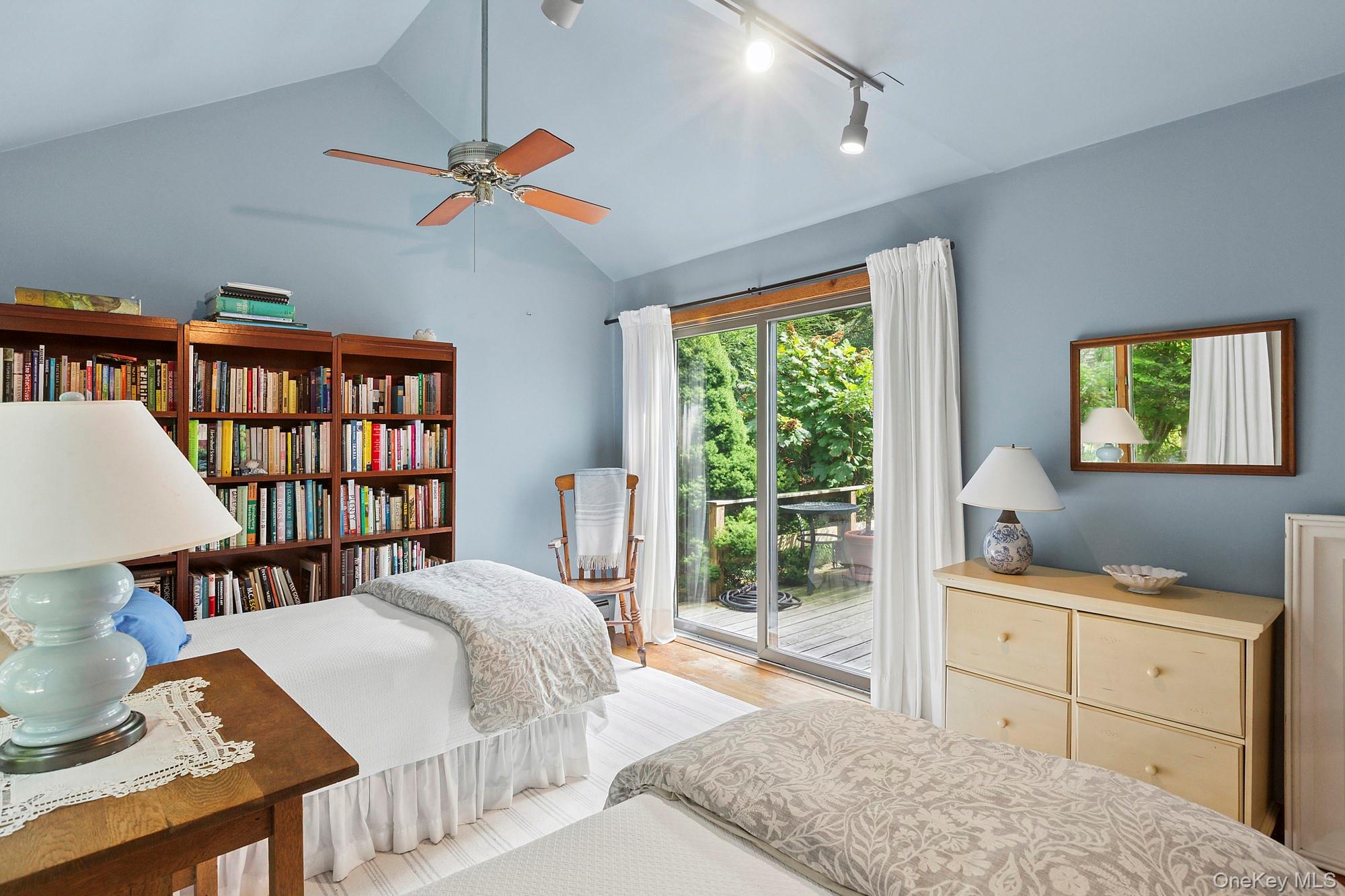 4528 Noyack Road Sag Harbor, NY 11963 - Photo 8 of 13 a bedroom with a bed a bookshelf and a large window