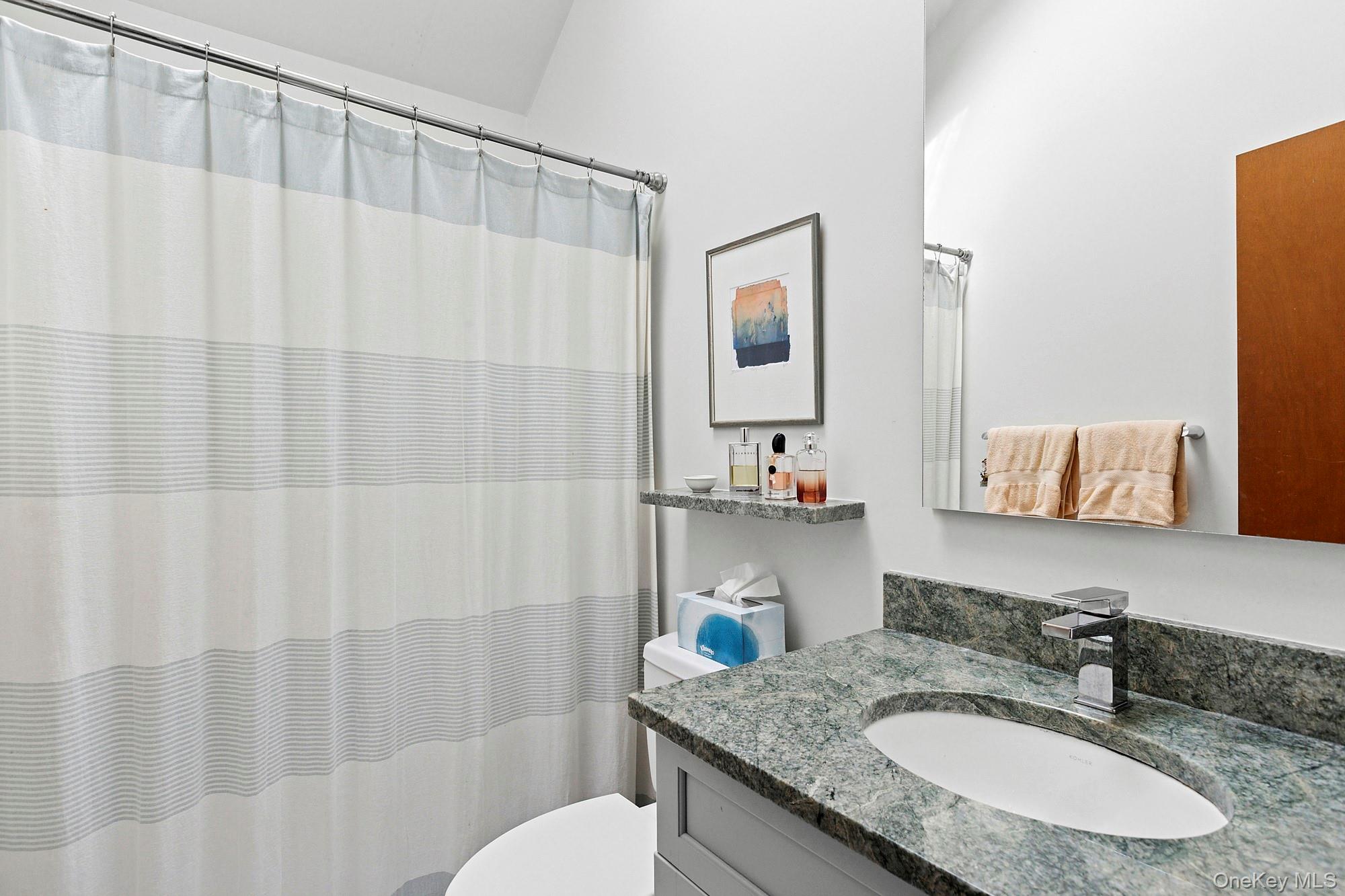 4528 Noyack Road Sag Harbor, NY 11963 - Photo 10 of 13 a bathroom with a granite countertop sink and a mirror