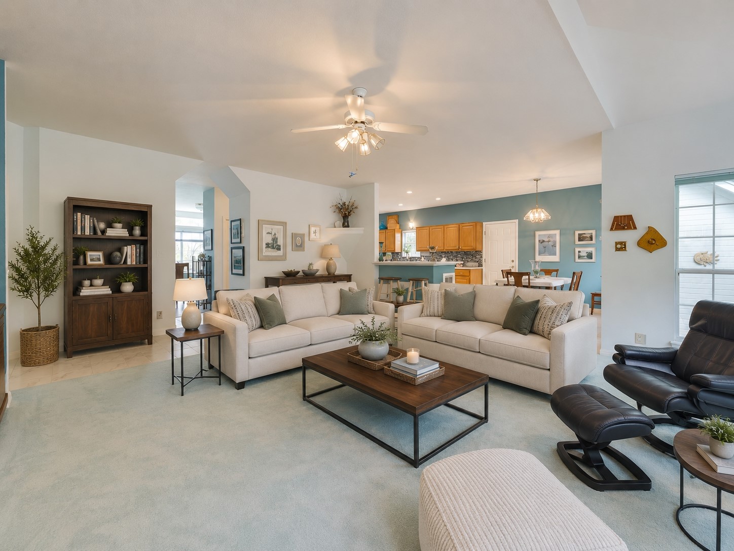 1602 Wild Basin Ledge Austin, TX 78746 - Photo 3 of 5 Open-concept living area featuring light blue carpeting, vaulted ceilings, a ceiling fan with integrated lighting, and arched doorways