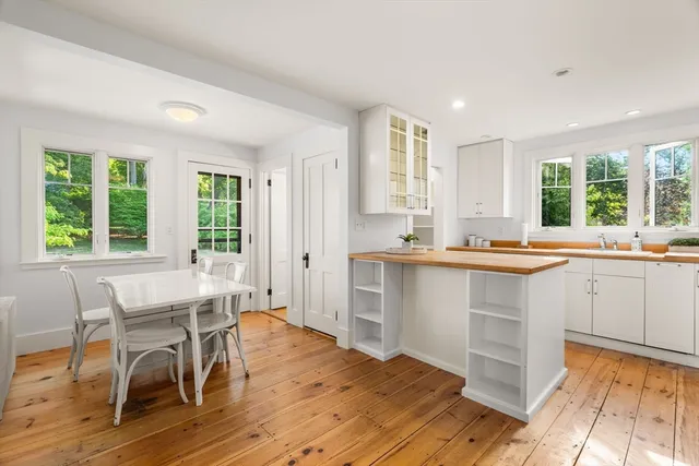a kitchen with a table chairs sink and cabinets