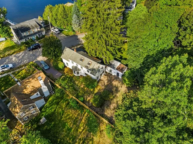 an aerial view of residential house with outdoor space and trees all around