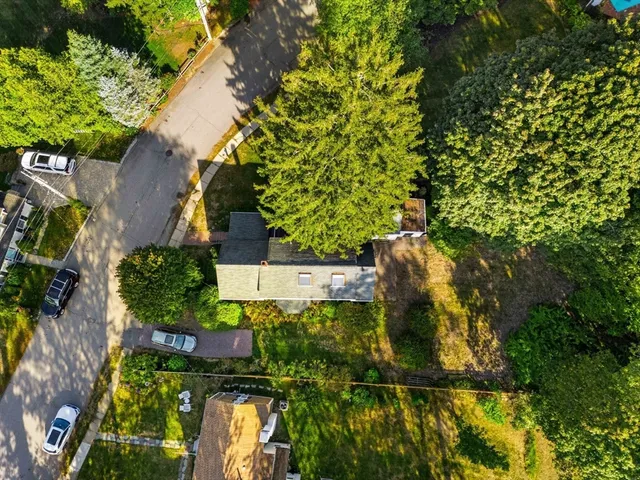an aerial view of residential house with outdoor space and trees all around