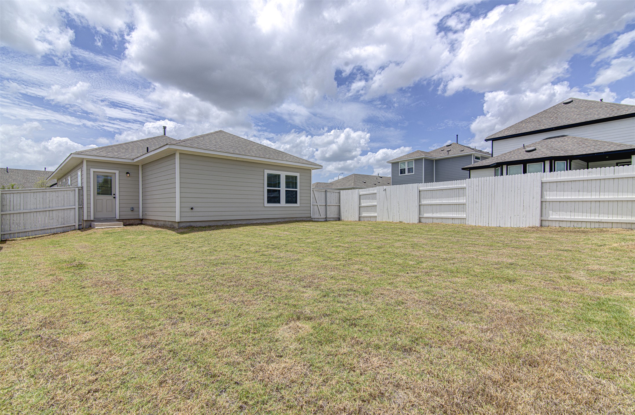 156 Tillage Road Elgin, TX 78621 - Photo 21 of 25 A generous backyard, fully fenced for privacy, offers ample space for outdoor enjoyment.