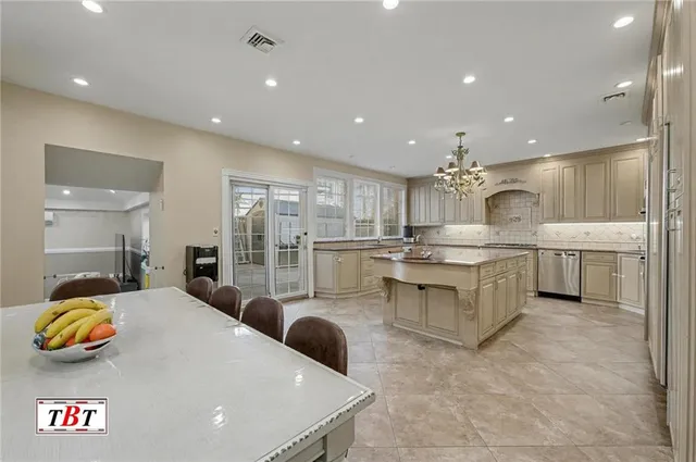 a kitchen with kitchen island granite countertop a sink a counter top stainless steel appliances and cabinets