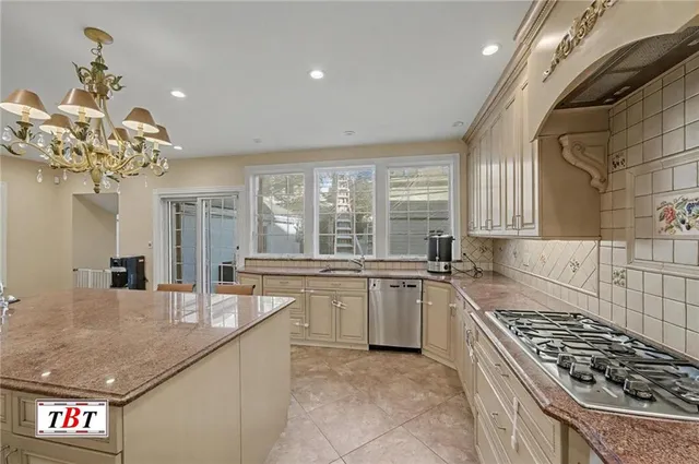 a kitchen with a sink a kitchen island and stainless steel appliances