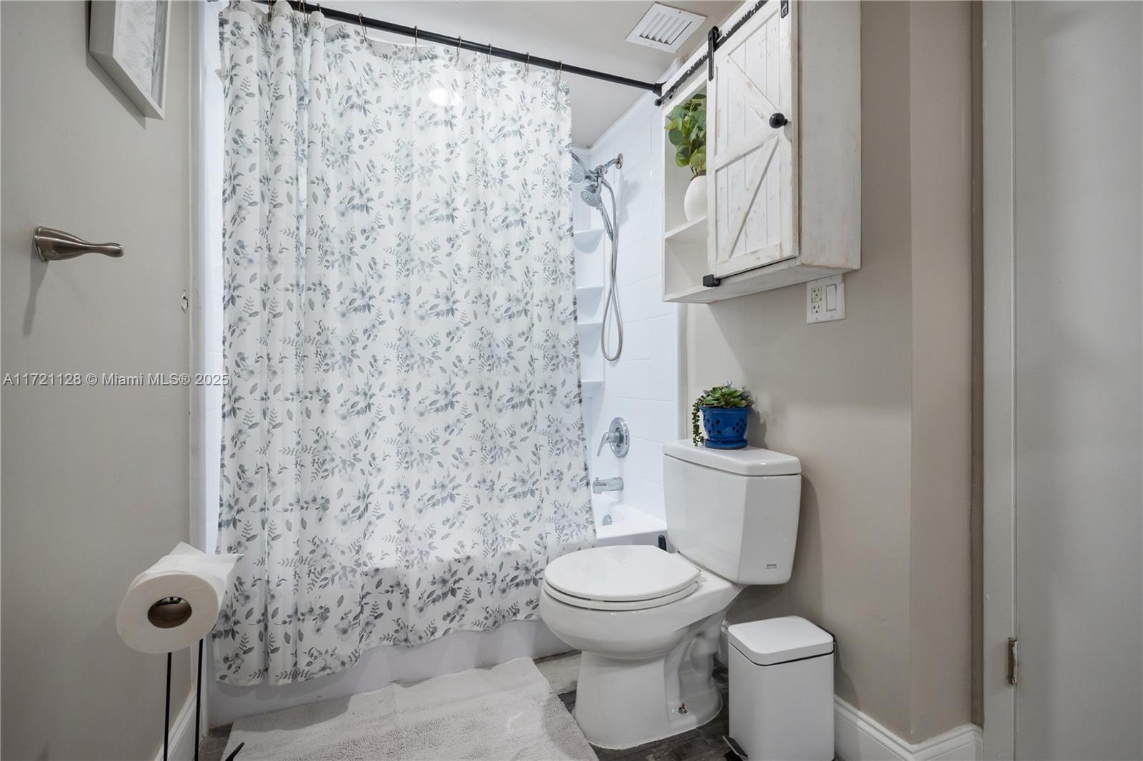 750 Northeast 64th Street, Unit B504 Miami, FL 33138 - Photo 17 of 37 a white toilet sitting next to a shower curtain