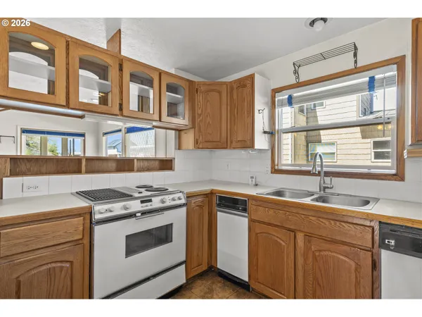 a kitchen with a stove a sink and a window