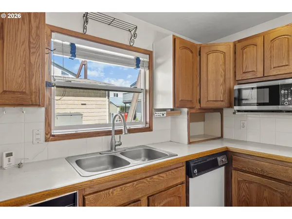 a kitchen with stainless steel appliances granite countertop a sink and a microwave