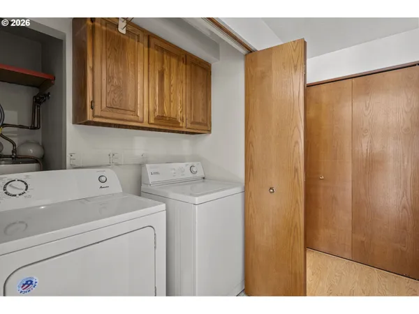 a view of an empty room with wooden floor and closet