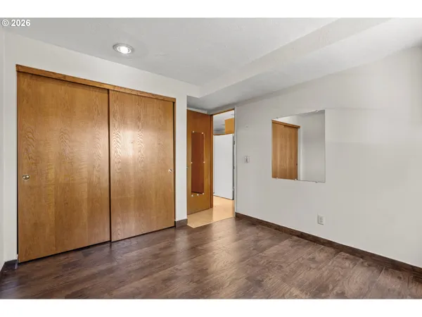 a spacious bedroom with a large bed a chandelier dresser and chair