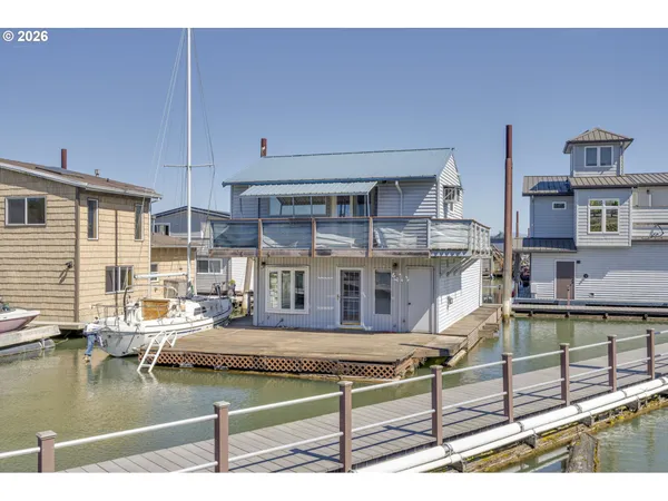 a living room with kitchen view and a wooden floor