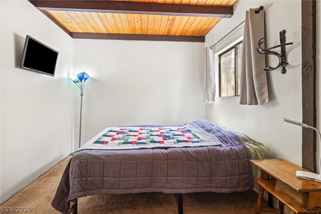 2146 Via Spes Nostra Street Mount Charleston, NV 89124 - Photo 21 of 33 A cozy bedroom with a striking wood plank ceiling and warm lighting.