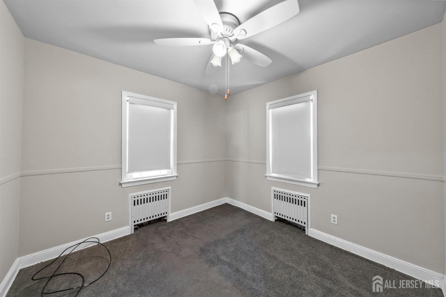 926 Hermann Road North Brunswick, NJ 08902 - Photo 16 of 54 an empty room with chandelier fan and windows