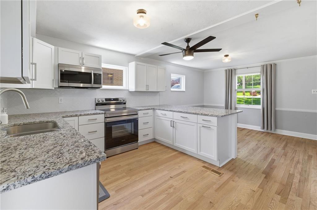 4883 East Willock Road Pittsburgh, PA 15227 - Photo 11 of 33 a kitchen with stainless steel appliances granite countertop a stove a sink and a microwave