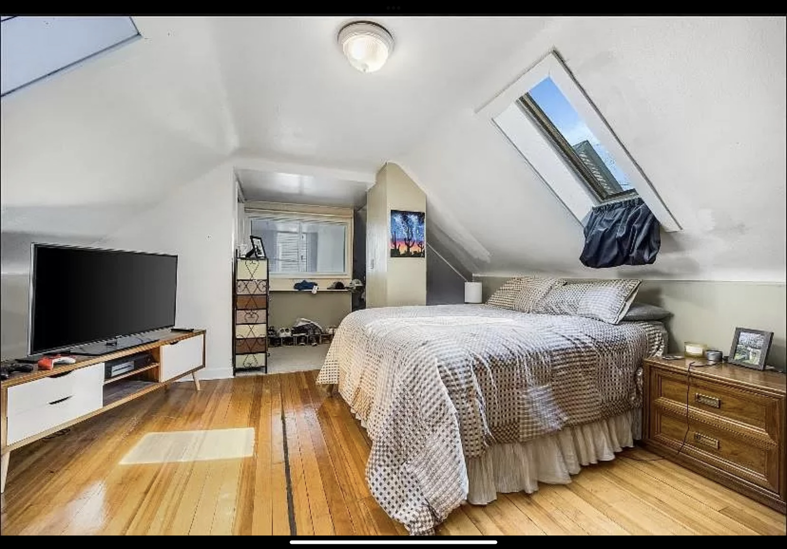 Undisclosed Address Chicago, IL 60657 - Photo 7 of 10 a bedroom with a bed and a flat tv screen on wall