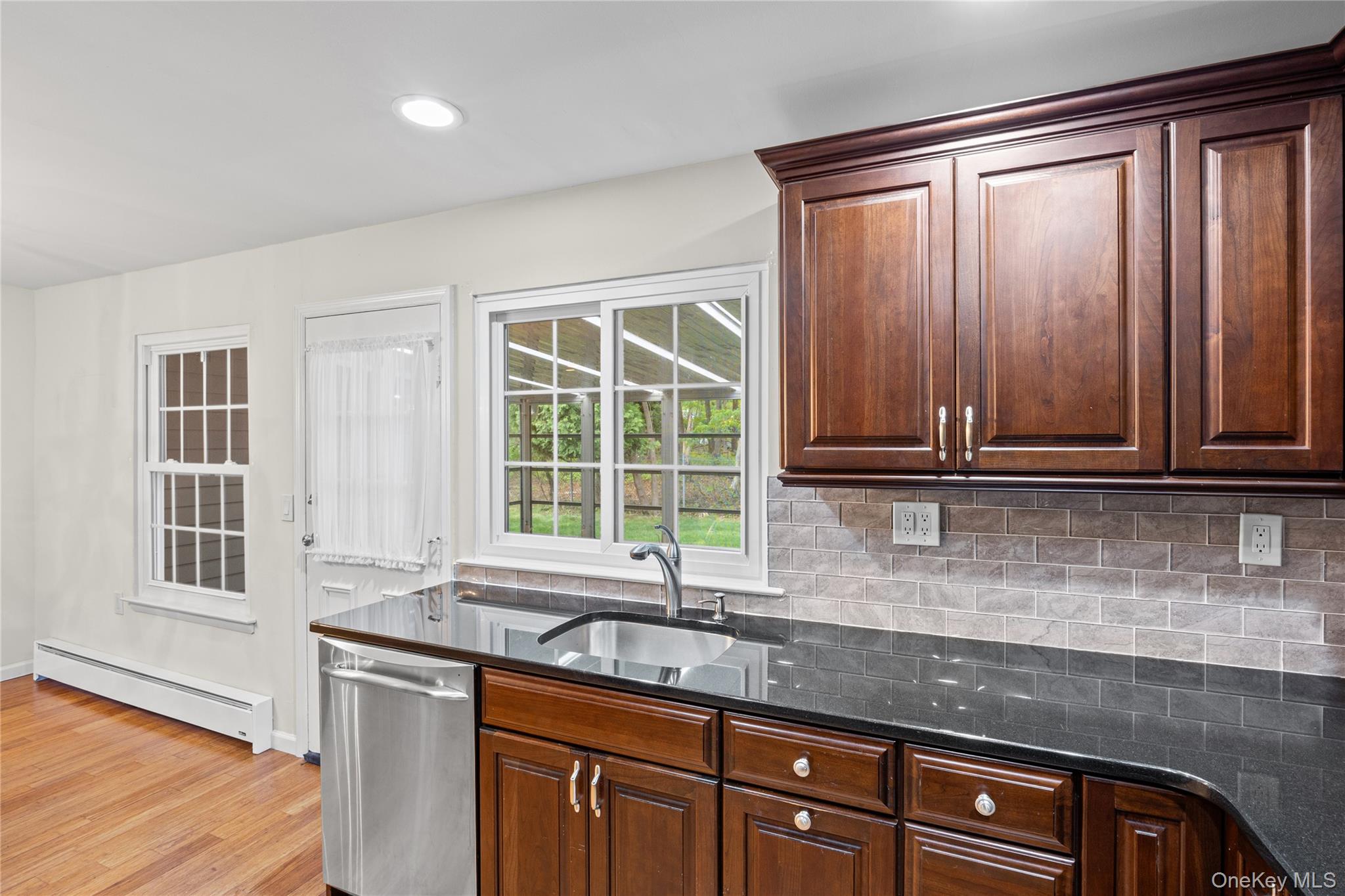 220 Belfast Lane Ridge, NY 11961 - Photo 24 of 44 a kitchen with stainless steel appliances granite countertop a sink and a window