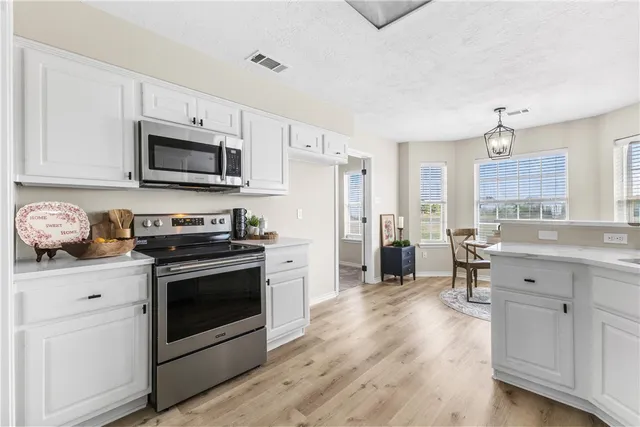 a kitchen with granite countertop a refrigerator stove and sink