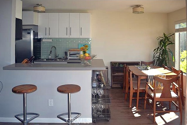 3111 4th Street, Unit 218 Santa Monica, CA 90405 - Photo 3 of 11 a kitchen with stainless steel appliances granite countertop a dining table chairs and granite counter tops