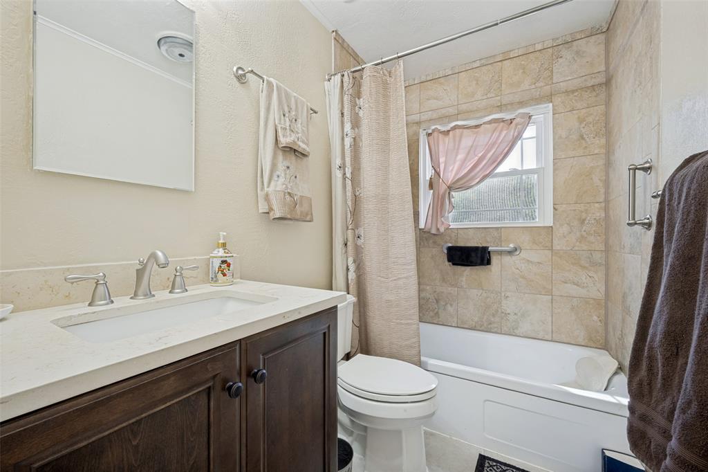 117 County Road Decatur, TX 76234 - Photo 12 of 40 Vanity with a white countertop and undermount sink, brushed nickel faucet, wood-finish cabinetry, and a mirrored medicine cabinet