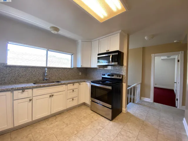 a kitchen with granite countertop cabinets and steel appliances