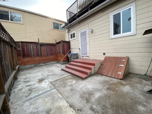 a backyard of a house with barbeque oven and outdoor seating
