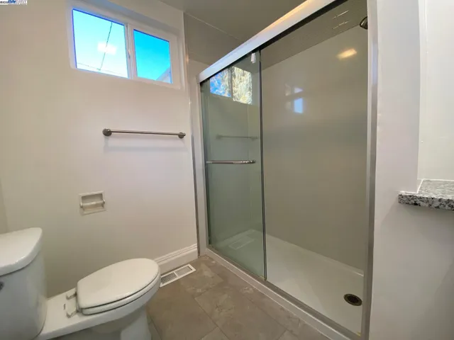 a bathroom with a toilet and a shower