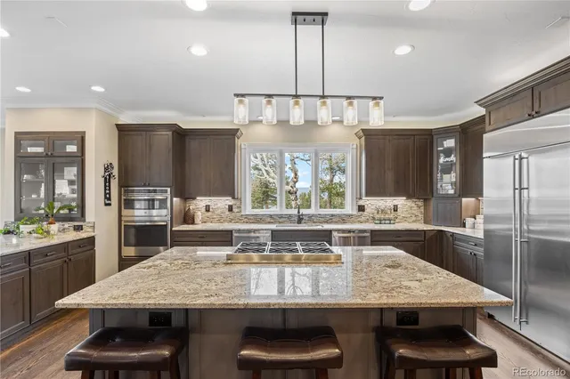 a kitchen with kitchen island granite countertop a table and chairs in it