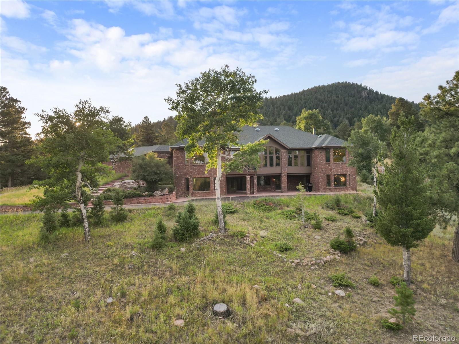 26269 Richmond Hill Road Conifer, CO 80433 - Photo 2 of 44 a view of a house with a yard