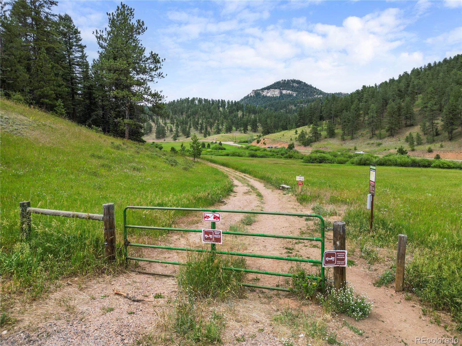 26269 Richmond Hill Road Conifer, CO 80433 - Photo 42 of 44 a view of park with bench next to lake view