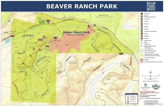 a view of a green field with lots of trees in the background