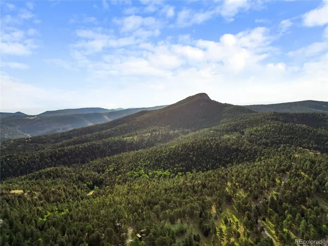 a view of a mountain range with lush green forest