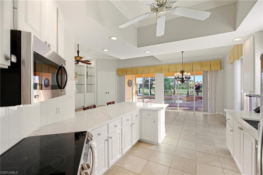7704 Hernando Court Naples, FL 34114 - Photo 10 of 41 a large white kitchen with a large window appliances and cabinets